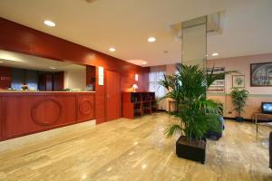 a waiting room with a potted plant in a lobby at Hotel Rex Milano in Milan