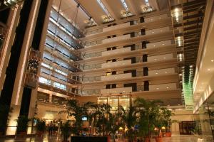 un grand bâtiment avec des palmiers dans un centre commercial dans l'établissement Pearl Continental Hotel, Lahore, à Lahore