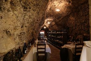 uma sala de degustação de vinhos numa gruta com mesas e garrafas de vinho em B&B Dei Raselli em Guardiagrele