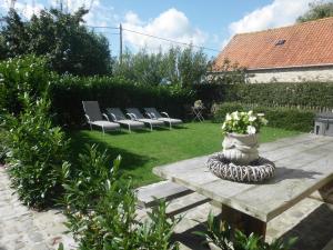 une table en bois avec un vase de fleurs. dans l'établissement Vakantiewoning 't Blooteland, à Dixmude