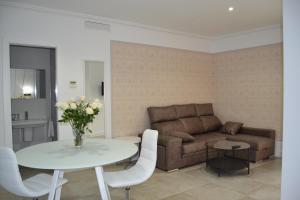 a living room with a couch and a table at Apartamentos Las Palmeras in Palma del Río