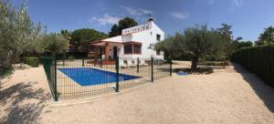 a house with a swimming pool behind a fence at Premium property Cap Roig Beach in L'Ampolla
