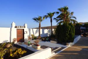 a courtyard with palm trees and a white building at Casa Berriel 2 in Tías