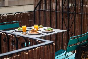 una mesa con dos platos de comida y dos vasos de zumo de naranja en Ten Hostel, en Ibiza