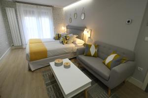 a hotel room with a bed and a couch at LEÓN SUITE Urban Studios in León
