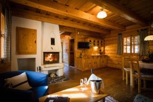 a living room with a fireplace in a log cabin at Hotel****Liptovský dvor in Liptovský Ján