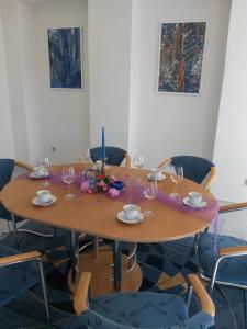a wooden table with wine glasses and flowers on it at Ubytovna Kubra in Hodonín