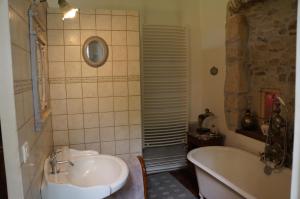 Un baño con bañera, lavabo y bañera. en la maison des chartreux, en Brives-Charensac 17 fotos más
