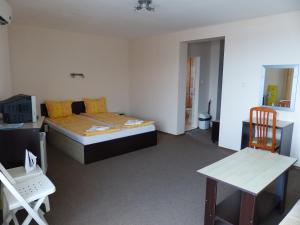 a bedroom with a bed and a desk and a table at Studio S - Vasiliko in Tsarevo
