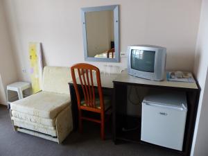a room with a desk with a tv and a chair at Studio S - Vasiliko in Tsarevo