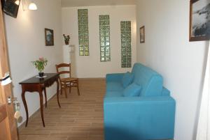 un soggiorno con divano blu e tavolo di A Casa di Nené a Palinuro