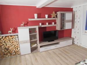 ein Wohnzimmer mit einem Entertainment-Center mit einem TV in der Unterkunft Ferienwohnung "Am Eisenbühl" in Berg