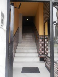 a stairway leading up to a hallway with white stairs at Hostal Carlos III in El Ejido