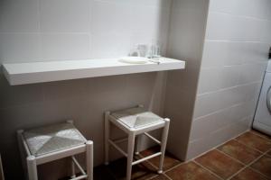 バレンシアにあるApartamento Serranos CMの小さなバスルーム(棚、スツール2脚付)