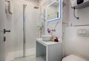 a white bathroom with a sink and a shower at Dream Luxury Rooms in Split
