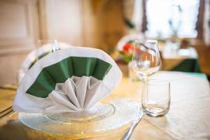 una mesa con un plato con una servilleta y dos vasos en Berggasthaus Agritur Moserhof en Braies