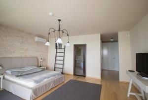 Dormitorio con escalera, cama y TV en Sozopol house in Sozopolis, en Sozopol 28 fotos más