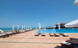 Una piscina con tumbonas y el océano. en Sozopol house in Sozopolis, en Sozopol