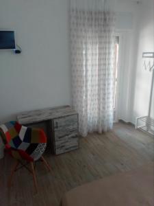 um quarto com uma cadeira, uma secretária e uma janela em Affittacamere Murgenere em Vico del Gargano