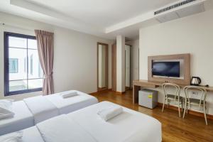a hotel room with a television and a bed at Panini Residence in Lat Krabang