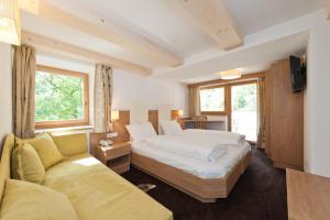una habitación de hotel con una cama y un sofá en Gasthof Zur Sonne, en Cardano