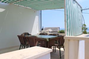 a patio with a table and chairs on a balcony at Apartmani Vinko Bol in Bol