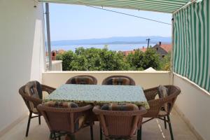 a table and chairs on a balcony with a view at Apartmani Vinko Bol in Bol