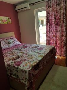 a bedroom with a bed with a flowered bedspread at Apartments Vila Galileo in Budva