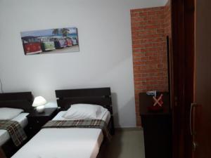 a room with two beds and a brick wall at Marina's Rooms in Larnaca