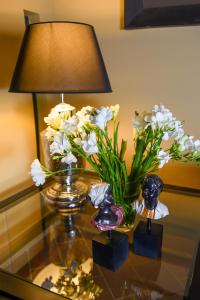 un tavolo di vetro con una lampada e fiori di Torre Di Vico Residenza D'Epoca a Viterbo