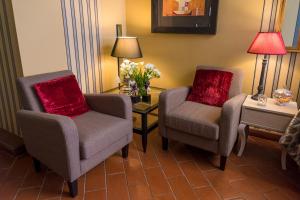 a living room with two chairs and a table with flowers at Torre Di Vico Residenza D'Epoca in Viterbo