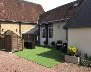 a small yard with green grass in front of a house at la bonbonniere in Saunay