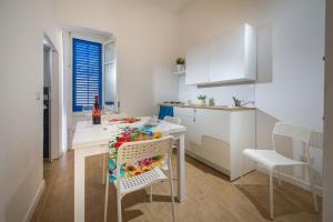 a kitchen with a table and chairs and a kitchen with white cabinets at Giulia's place-Locazione Turistica in Castellammare del Golfo