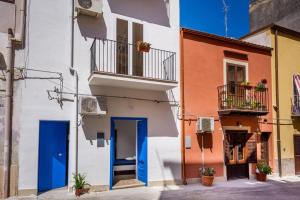 a building with a blue door on a street at Giulia's place-Locazione Turistica in Castellammare del Golfo