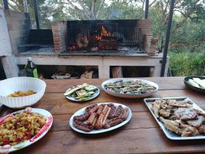 a wooden table with plates of food and a grill at Elba Residence in Capoliveri
