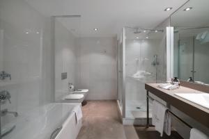 
a bathroom with a tub, sink, and shower at Catalonia Catedral in Barcelona
