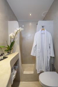 a white robe is hanging in a bathroom at Agnadi Hotel in Agia Anna Naxos