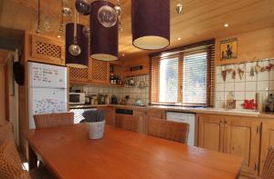 a kitchen with a wooden table and a refrigerator at 65m2 - balcon et vue sur les Aravis in La Giettaz