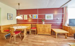 uma sala de jantar com mobiliário em madeira e uma televisão em Appartements Alpin em Saalbach-Hinterglemm