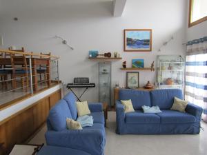 uma sala de estar com dois sofás azuis em Casa da Buzina em Nazaré