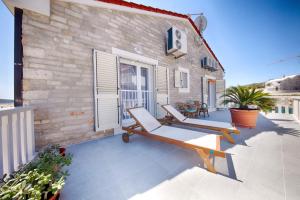 a patio with two lounge chairs and a building at Apartments Dalmatino in Rukavac