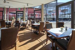 a restaurant with tables and chairs and windows at vevio - Hotel & Events in Spiesen-Elversberg +22 photos