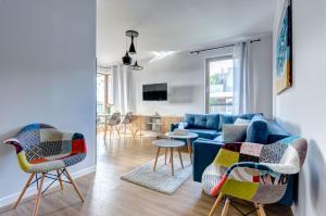 a living room with a blue couch and chairs at Amber Baltic Apartment in Gdańsk