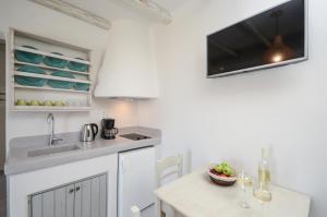 a kitchen with a sink and a counter with a table at Agnadi Hotel in Agia Anna Naxos