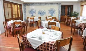 ein Esszimmer mit Tischen und Stühlen mit weißem Tischtuch in der Unterkunft Hotel São Francisco in Horta