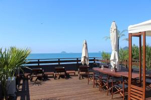 un ponte di legno con tavolo, sedie e ombrelloni di なにもない幸せな島のリトリート宿 THE BONDS Island Stay a Matsuyama