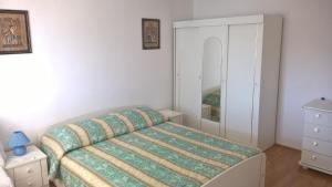 a small bedroom with a bed and a mirror at Captain Apartments in Vinišće