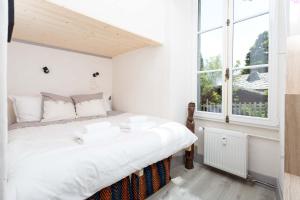 a bedroom with a large white bed with a window at Appartement Cocon in Chamonix-Mont-Blanc