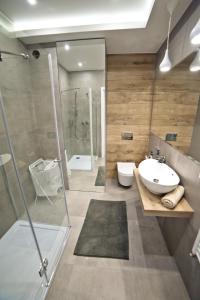 W łazience znajduje się prysznic, umywalka i toaleta. w obiekcie Post Apart - Apartamenty w Centrum w mieście Krynica Zdrój