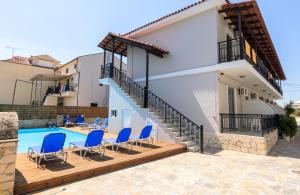 a villa with a swimming pool and blue chairs at Karras Livin in Laganas